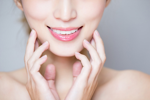 女性の白い歯｜close up of beauty woman tooth on the gray background